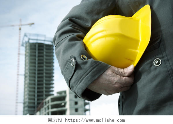 商务建筑工地背景工人手拿黄色安全帽特写